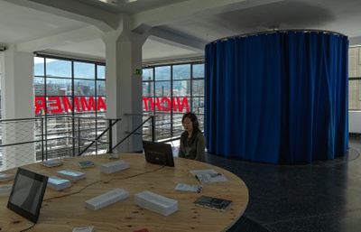 Blick in die Ausstellung „Legislating Architecture“ mit „Fernsehzimmer“ und Schriftzug „Nicht Jammern“