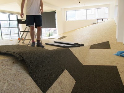 Ausstellungsaufbau - Tag 16: Die Unterkonstruktion ist fertig - jetzt kann der Teppichboden verlegt werden.